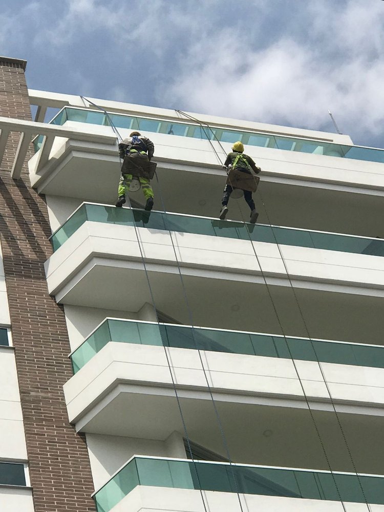 Equipe da AM Edificações em trabalho de altura na fachada de um prédio